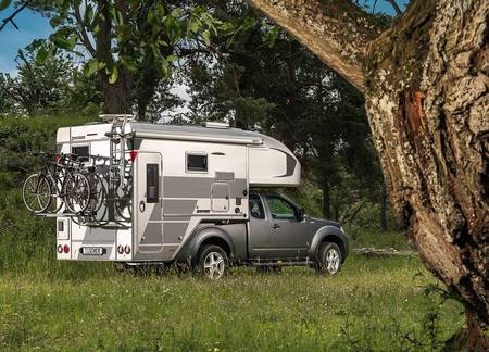 Tischer pickup camper TRAIL 260SD på en silverfärgad Nissan Navara med omtypning och höjda vikter stående i en skog 